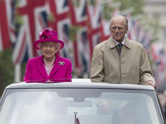 The Queen and Prince Philip are driven along the Mall during the Patron's Lunch, a special street party outside Buckingham Palace in 2016. Picture: AFP