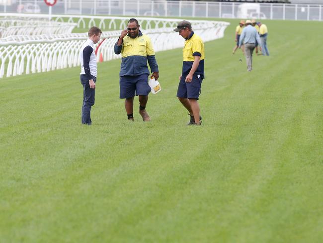 Groundsmen check out the track surface between trials at Eagle Farm recently. Picture: Jono Searle