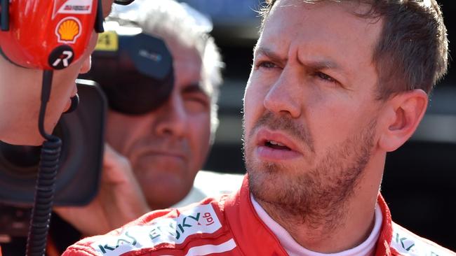 Ferrari's German driver Sebastian Vettel (R) talks with his team staff before the start of the Formula One Japanese Grand Prix at Suzuka on October 8, 2017. / AFP PHOTO / Kazuhiro NOGI