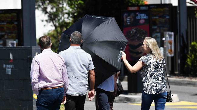 Cantarella (middle, white shirt under umbrella) leaving the court with his supporters following his sentence. Picture: Patrick Woods