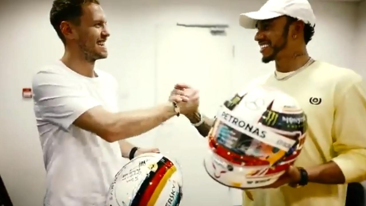 F1 foes Sebastian Vettel and Lewis Hamilton swap helmets.