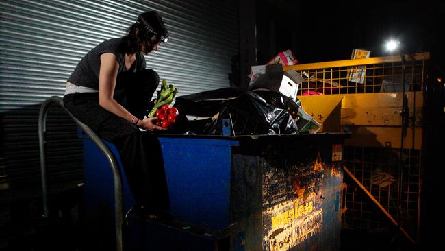 A girl goes "dumpster diving" a trend where people raid the bins of supermarkets to "rescue" food that is still good.