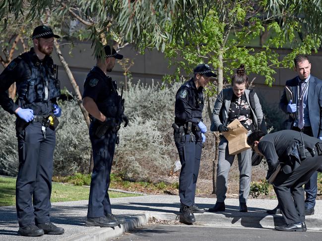 Police and detectives examine the scene after a man was seriously assaulted at Adelaide High School overnight. Picture: Naomi Jellicoe