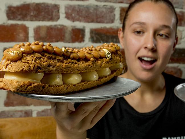 Emma Clark from  Bam Bam Bakehouse  holding the new King Size Caramel Æclair and the normal sized  Caramel Æclair, both on the same sized plate.  Picture:  Jerad Williams