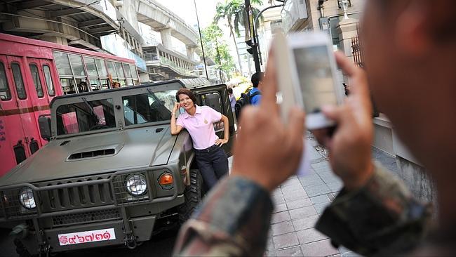 A woman poses with an army vehicle after martial law was declared in Thailand. Picture: Getty