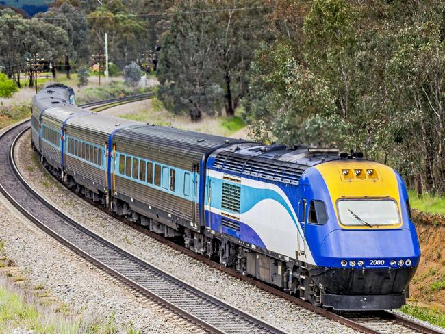 Cootamundra, Australia - Sept 30, 2016: The Countrylink XPT fast passenger train operating between Sydney & Melbourne rounds a curve in hilly rural landscape on a wet, overcast day. A High Speed Train operating between the two main Australian cities, powered by renewable energy, would replace the slow and inefficient diesel-powered service. Metaphor for cloud hanging over the future of the rail service.credit: istockescape2 may 2021kendall hill