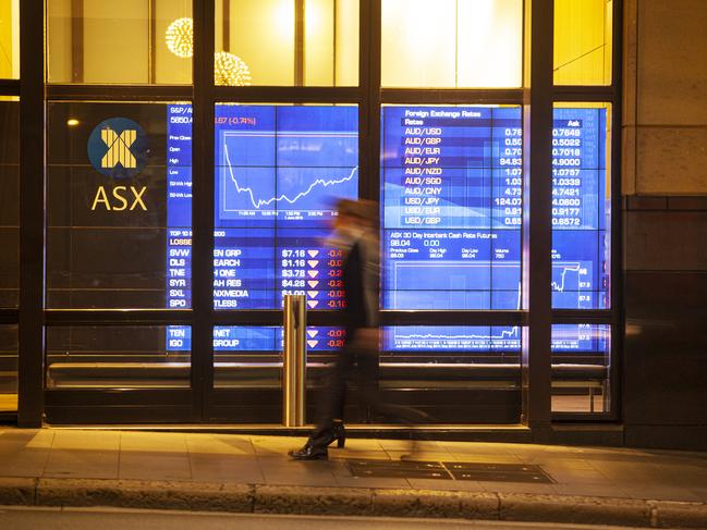 A man in corporate suit walked past ASX (Australian Stock Exchange)