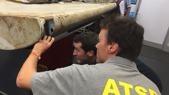 ATSB officials with a part of a wing flap from MH370. Picture: AFP