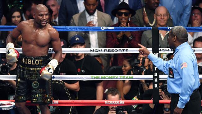 LAS VEGAS, NV — AUGUST 26: Referee Robert Byrd (R) directs Floyd Mayweather Jr. to go back to his corner at the end of the fifth round of his super welterweight boxing match against Conor McGregor at T-Mobile Arena on August 26, 2017 in Las Vegas, Nevada. Mayweather won by 10th-round TKO. Ethan Miller/Getty Images/AFP == FOR NEWSPAPERS, INTERNET, TELCOS &amp; TELEVISION USE ONLY ==