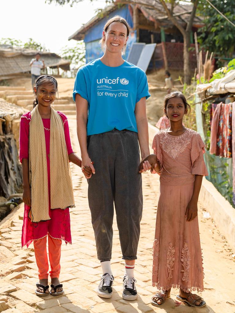 Emma McKeon walks through the camp with Mabiya and Umekulsum. Picture: Jason Edwards