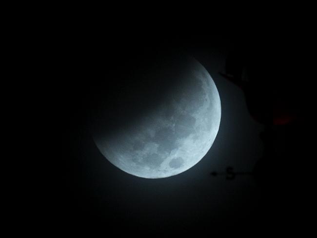 The Earth’s shadow begins to fall on the moon during a total lunar eclipse, as seen above Miami, Florida. Picture: AP