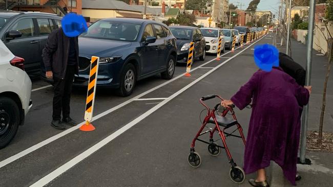 An elderly Elizabeth St residents crosses the protected bike path to reach the car.