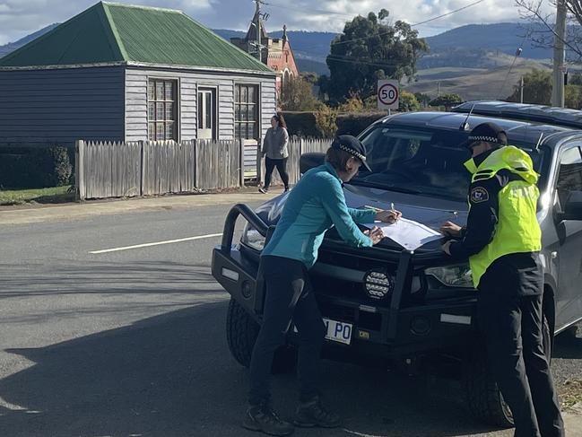 Police examine a map only a few hundred metres away from where Ms Direen was found. Picture: Ed Bourke