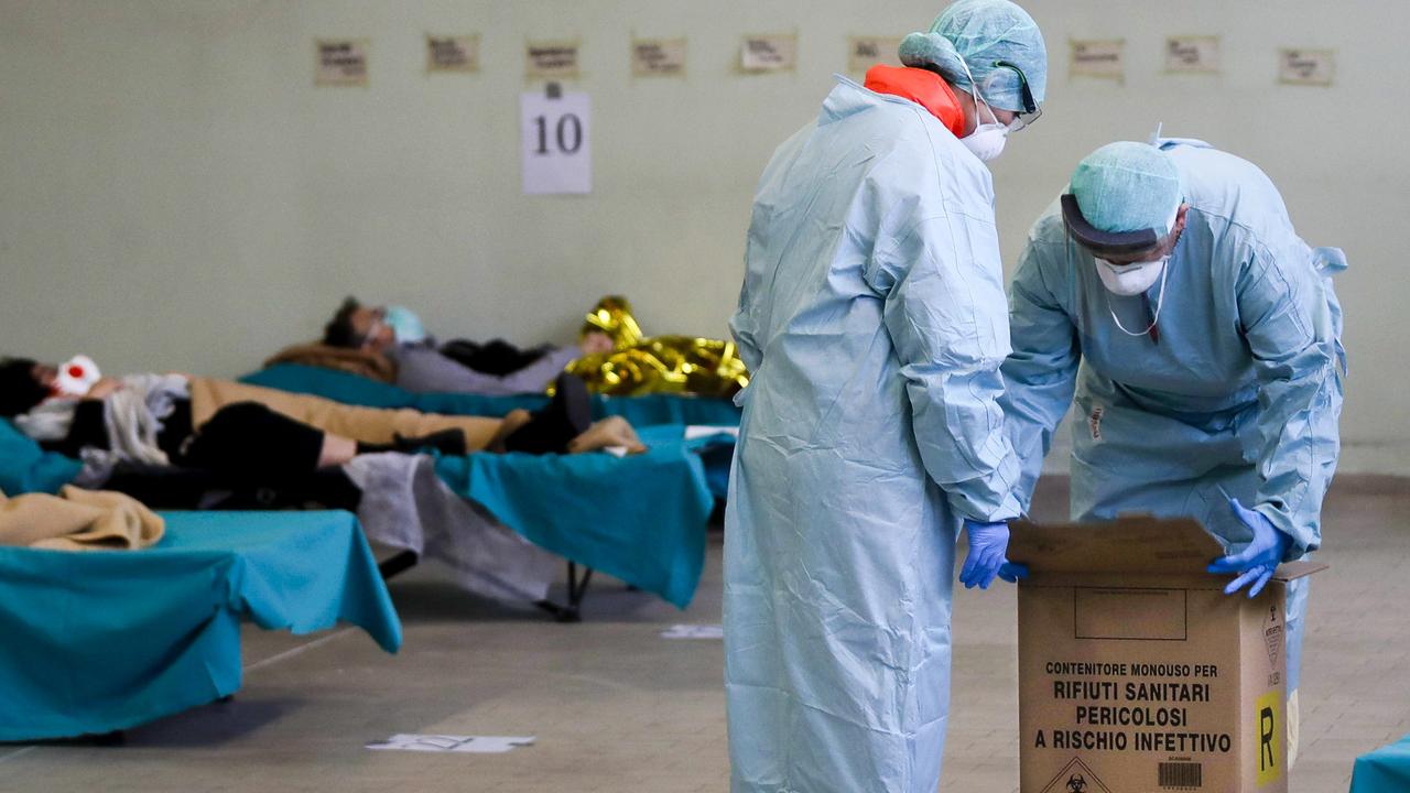 Paramedics inspect hazardous medical waste box as patients lie on camping beds in Lombardy’s makeshift A&amp;E department. Picture: Luca Bruno.