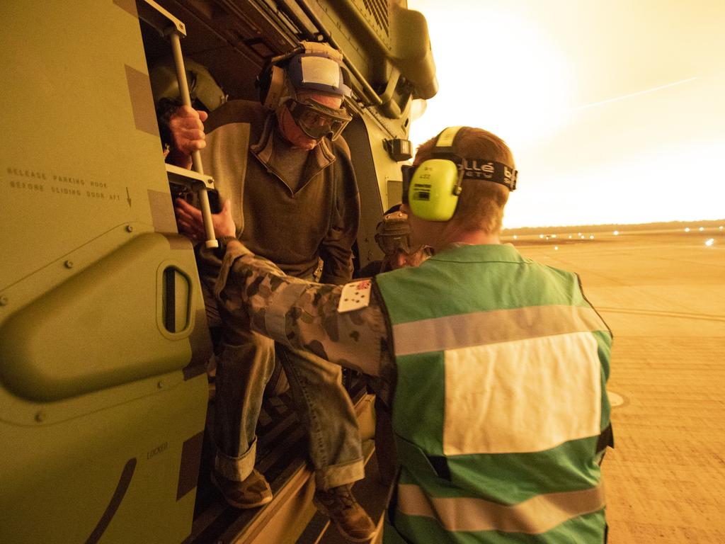 Mr Frank Delaney of Yalwal, NSW, is assisted from an 808 Squadron MRH90 Military Support Helicopter after being evacuated from his remote rural property to the east of the Moreton National Park. Picture: ADF