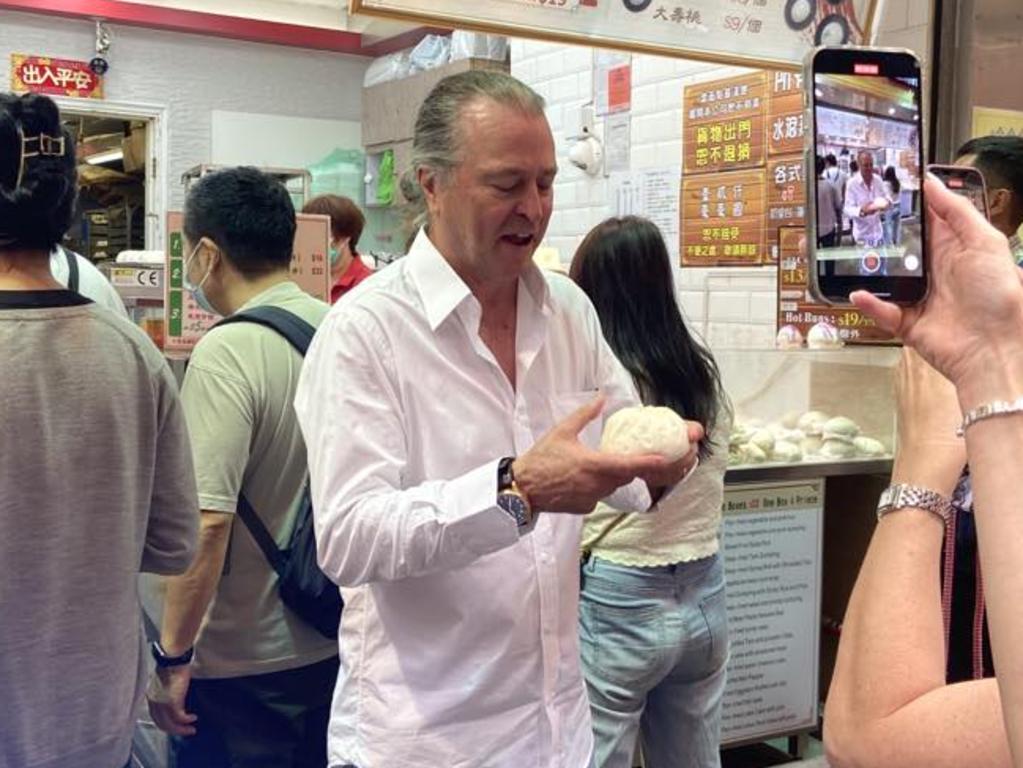 Famed chef and Qantas’ creative director of food, beverage and service Neil Perry tries one of the steamed buns at Bao Dim Tat Yan. Picture: news.com.au