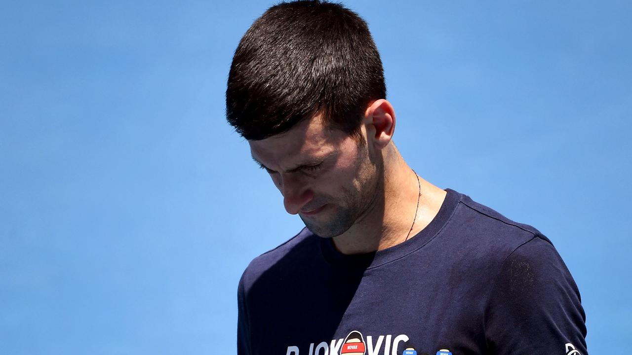 (FILES) In this file photo taken on January 12, 2022, Novak Djokovic of Serbia looks at his racquet during a practice session ahead of the Australian Open at the Melbourne Park tennis centre in Melbourne. - Novak Djokovic lost his bid to avoid deportation from Australia on January 16, 2022, with a Federal Court unanimously rejecting his appeal to stay in the country and defend his Australian Open title. (Photo by William WEST / AFP) / -- IMAGE RESTRICTED TO EDITORIAL USE - STRICTLY NO COMMERCIAL USE --