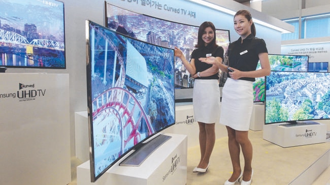 Models pose with a Samsung Electronics curved UHD television.