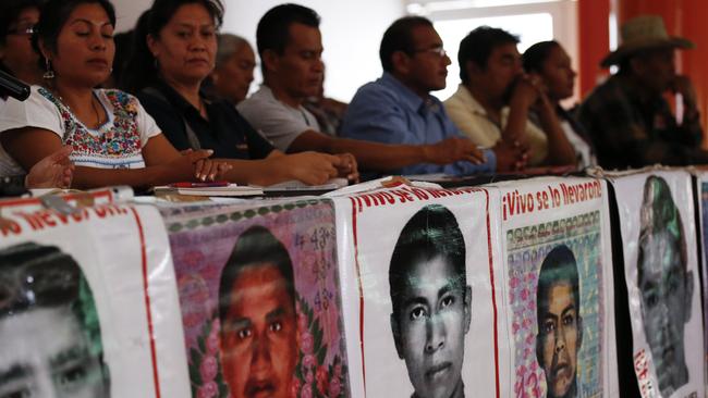 Parents of some of the 43 missing teacher's college students sit behind posters depicting their missing loved ones. Picture: AP