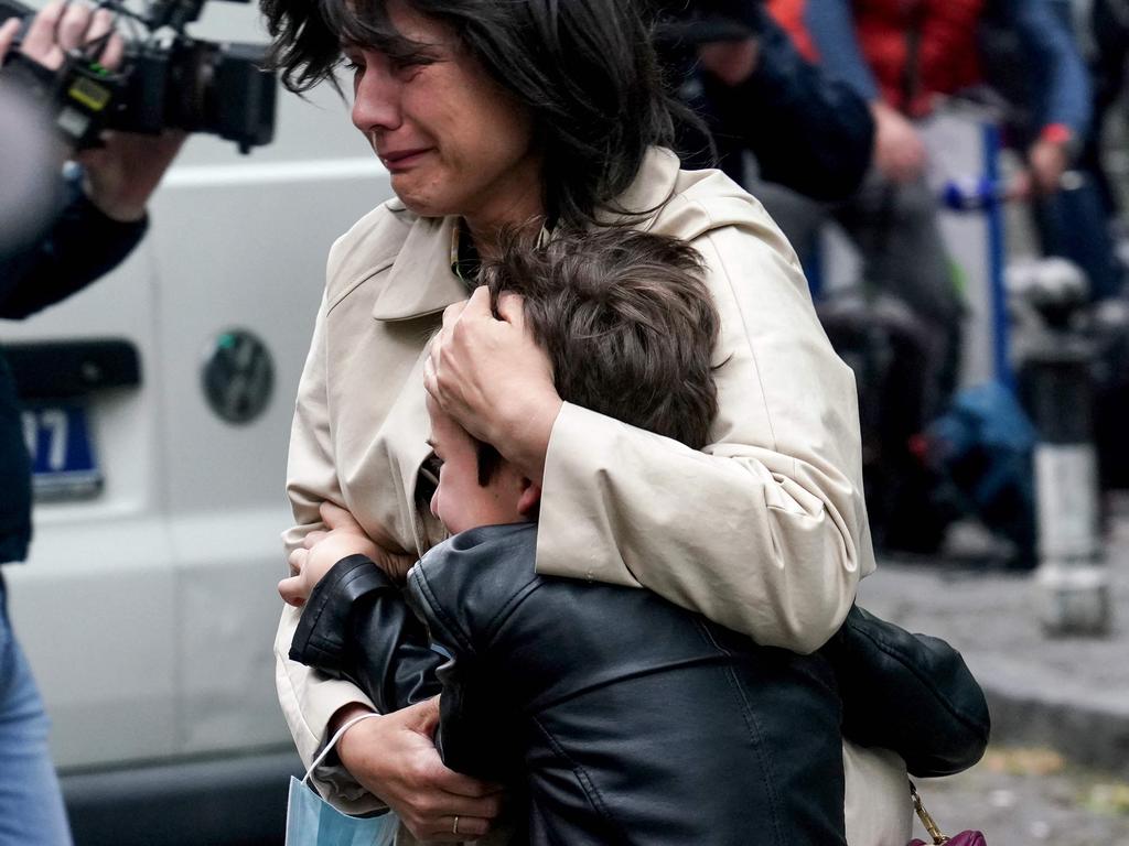 A parent escorts her child following a shooting at the school. (Photo by Oliver Bunic / AFP)