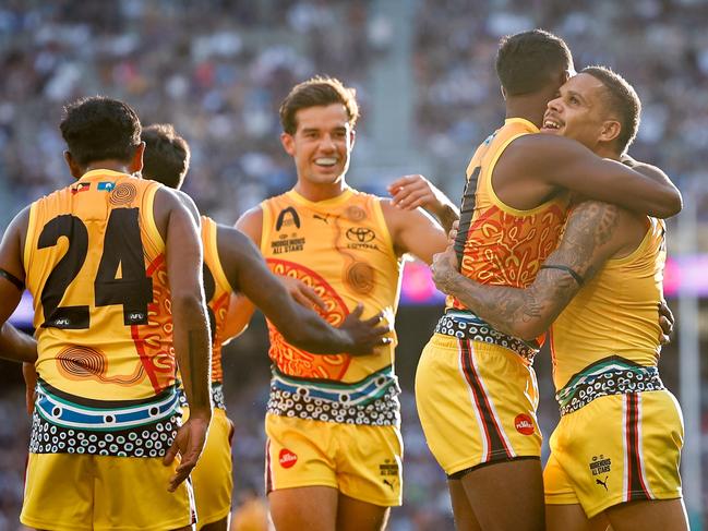 Bobby Hill of the Indigenous All Stars celebrates a goal with teammates. Picture: Dylan Burns/AFL Photos via Getty Images.