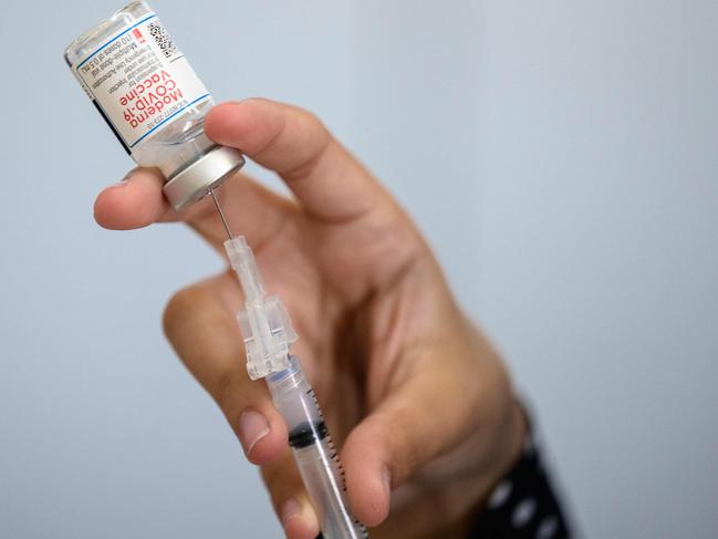 (FILES) In this file photo taken on April 16, 2021 a medical staff member prepares a syringe with a vial of the Moderna Covid-19 vaccine at a pop up vaccine clinic at the Jewish Community Centerin the Staten Island borough of New York City. - An expert committee on October 14, 2021 recommended a booster dose of Moderna's anti-Covid vaccine in the United States for certain at-risk groups, a month after making a similar decision for the Pfizer shot. (Photo by Angela Weiss / AFP)