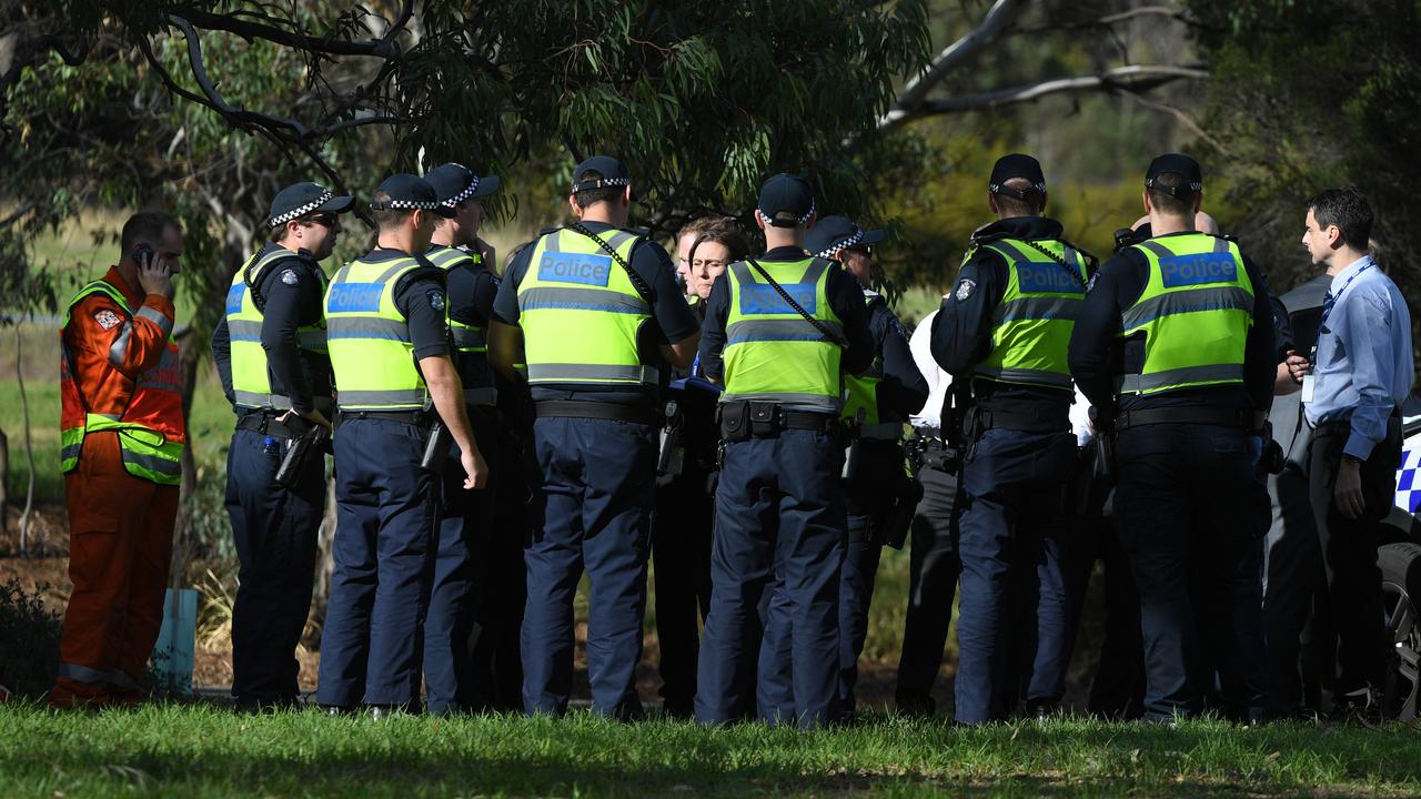 Police are seen at a staging point in Royal Park, Melbourne, after a woman's body was found at Parkville. Picture: AAP Image/James Ross.