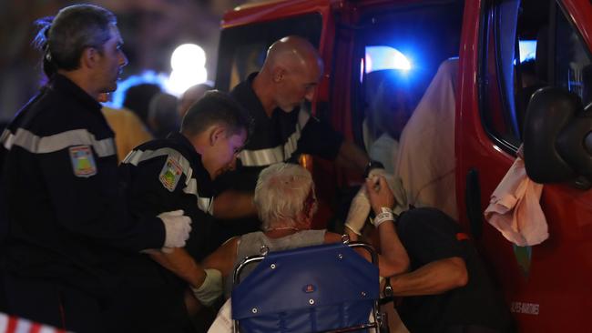 Rescue workers help an injured woman to get in an ambulance. <i>Picture: AFP/Valery Hache</i>