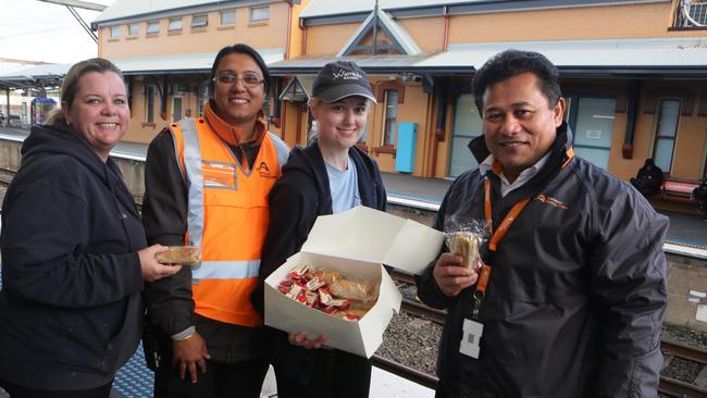 Waminda Bakery staff hand out free pies and sausage rolls to staff and commuters at Campbelltown Station.