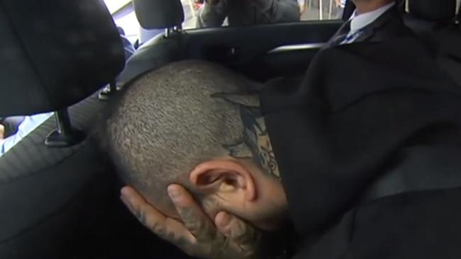 Josh Rider covers his face after his arrest. Picture: 7 News