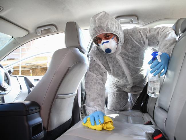 Uber driver Yasar Gorur cleans his car in East London. Coronavirus deaths in the UK could be higher than reported. Picture: Getty Images