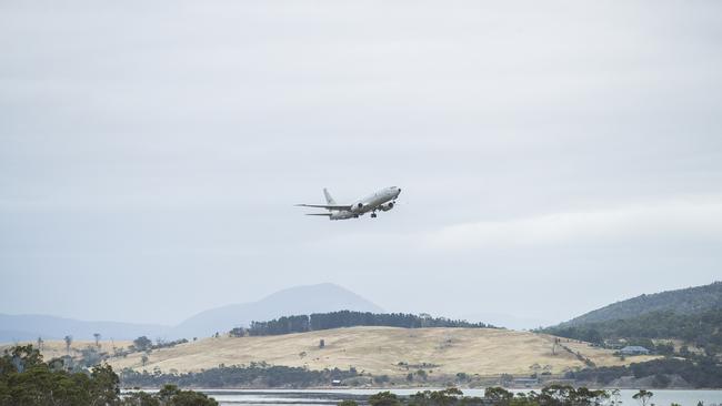 An aircraft flies over Hobart Airport. Picture: RICHARD JUPE