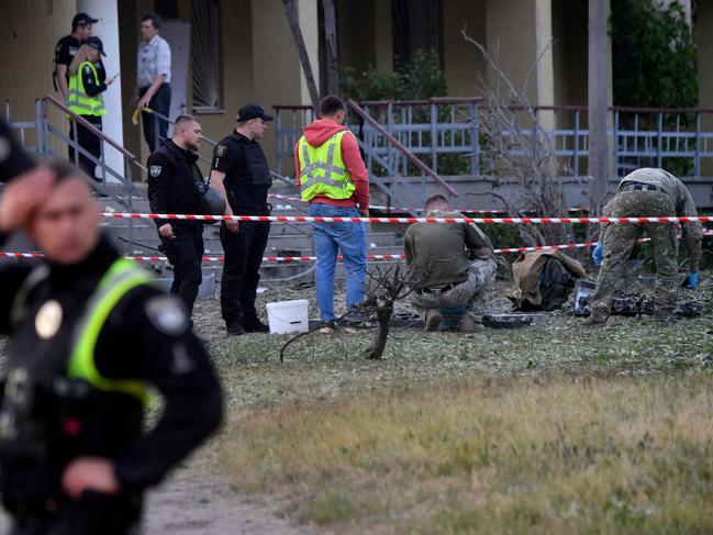 Experts look for fragments of a downed missile exploded outside a polyclinic during the Russian attack on Kyiv. Picture: AFP