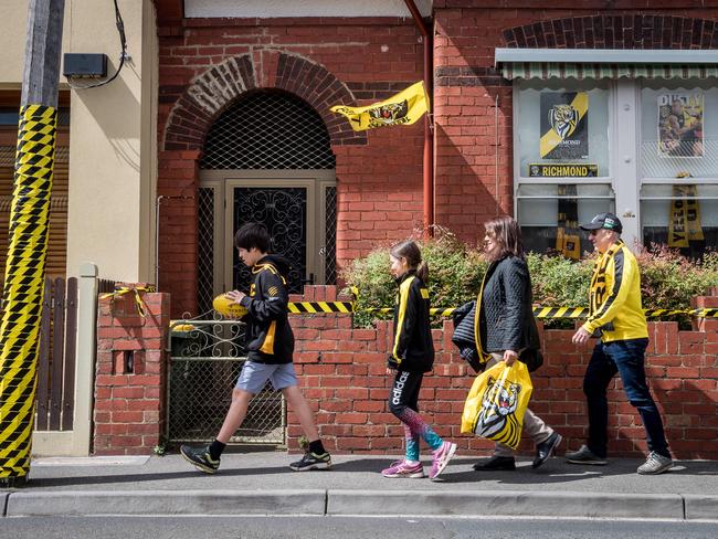 Supporters walk past a decorated house in Woodlawn Street, Richmond. Picture: Jake Nowakowski