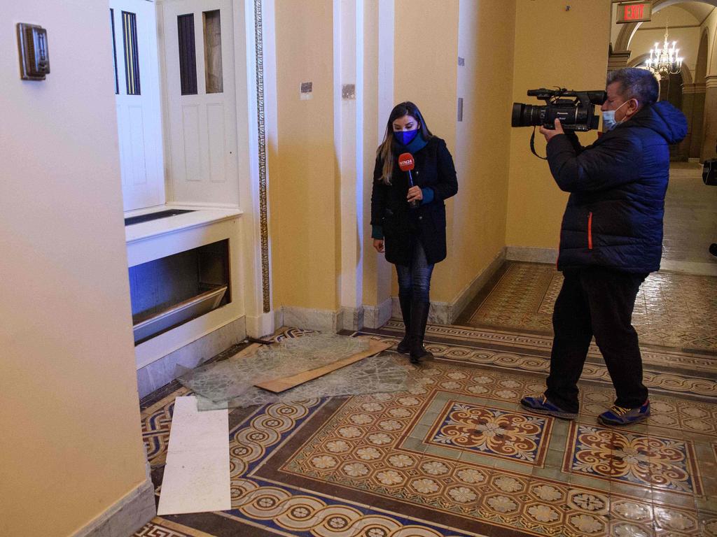 A television crew films damage in a hallway of the Capitol a day after supporters of outgoing President Donald Trump stormed the building. Picture: Nicholas Kamm / AFP)