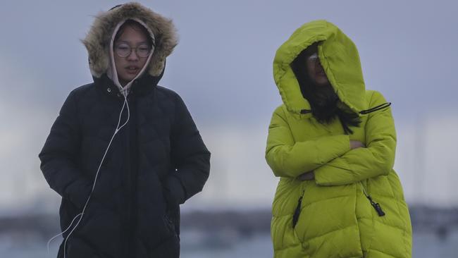 Walkers rugged up at St Kilda Pier. Picture: Wayne Taylor