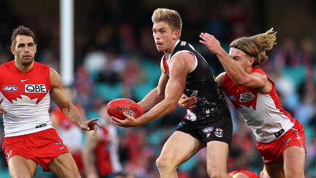 Seb Ross looks to get a handball away in the clash with Sydney at the SCG. Picture: Cameron Spencer/Getty Images)