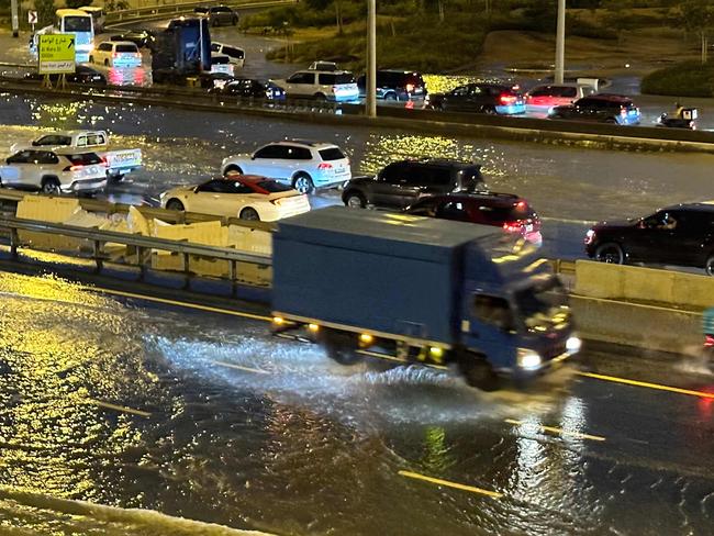 Cars and trucks try to navigate flooded streets following heavy rains in Dubai. Picture: AFP