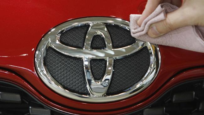 An employee at Toyota Motor Corporation's showroom polishes a Toyota logo on a vehicle in Tokyo, Japan 06/01/2009.