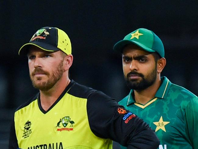 Australia's captain Aaron Finch (L) and his Pakistan's counterpart Babar Azam arrive for the toss before the start of the ICC menâs Twenty20 World Cup semi-final match between Australia and Pakistan at the Dubai International Cricket Stadium in Dubai on November 11, 2021. (Photo by INDRANIL MUKHERJEE / AFP)