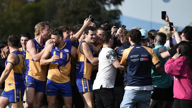 Sunshine’s Nathan Carrol is swarmed after he slots his 100th goal. Picture: Andrew Batsch