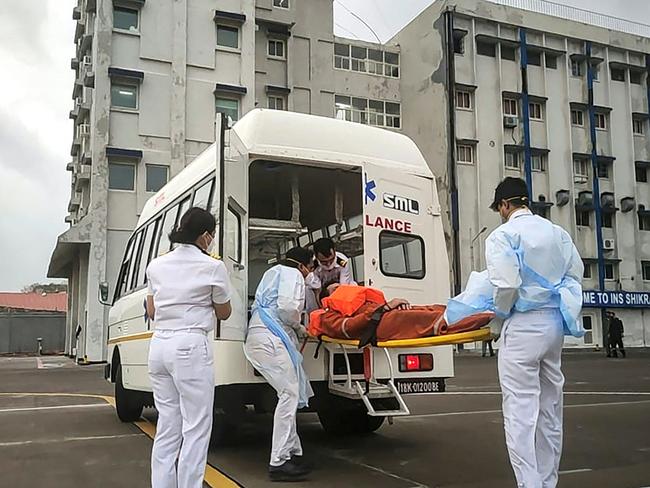 Naval personnel help the injured from Barge P305 to board an ambulance for medical attention in Mumbai. Picture: AFP