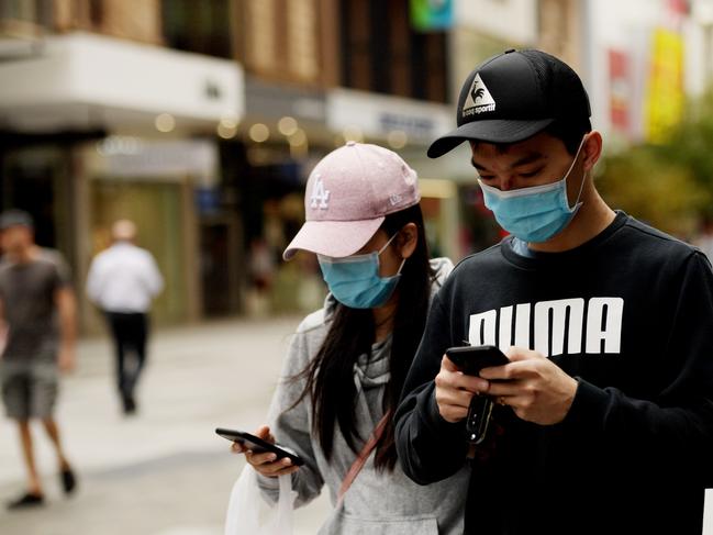 ADELAIDE, AUSTRALIA - APRIL 01: People wear surgical masks in Adelaide on April 01, 2020 in Adelaide, Australia. The Australian government has introduced further restrictions on movement and gatherings in response to the ongoing COVID-19 pandemic. Public gatherings are now limited to two people, while Australians are being urged to stay home unless absolutely necessary. New South Wales and Victoria have also enacted additional measures to allow police the power to fine people who breach the two-person outdoor gathering limit or leave their homes without a reasonable excuse. Queensland, Western Australia, South Australia, Tasmania and the Northern Territory have all closed their borders to non-essential travellers and international arrivals into Australia are being sent to mandatory quarantine in hotels for 14 days. (Photo by Tracey Nearmy/Getty Images)