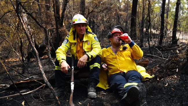 RFS firefighters Wayne Everett (L) and Dave Theodorou break for Christmas lunch while working to clear containment lines in bushland in the Blue Mountains. Picture: Sam Mooy