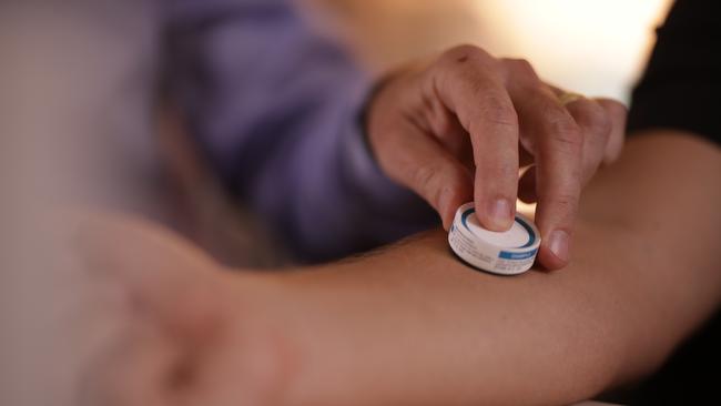 The patch being applied to a person's arm.