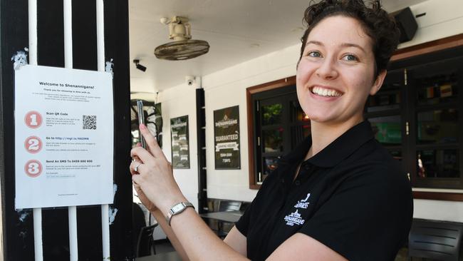 Holly Smith, a waitress at Shenannigans, showing how people can scan into the popular Darwin watering hole. Picture: Katrina Bridgeford.