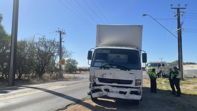 Police talk to the truck driver by the truck involved with the incident. Picture: Jason Katsaras