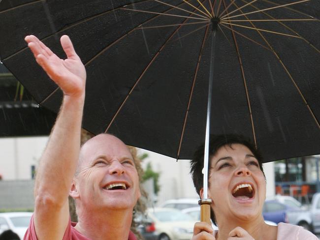 Opening of Bayside Park in Manly . Lord Mayor Campbell Newman with wife Lisa sheltering from the rain under an umbrella watch children climb the Space Net .