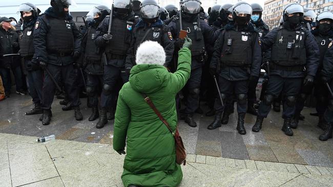 A woman holding an icon kneels in front of a group of riot police during a rally in support of jailed opposition leader Alexei Navalny in downtown Moscow on January 23, 2021. Picture: Kirill Kudryavtsev/AFP