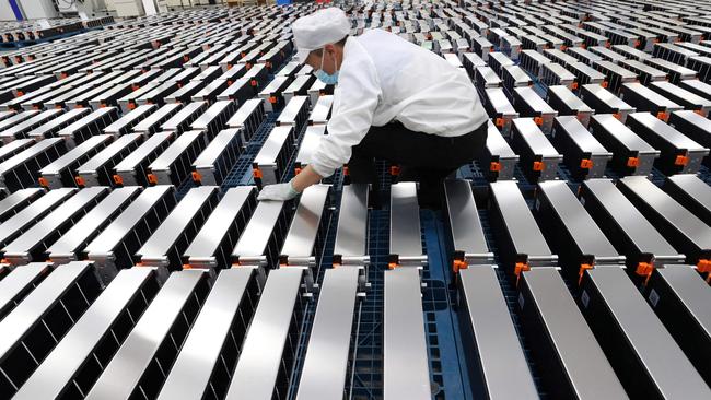 (FILES) This file photo taken on March 12, 2021 shows a worker with car batteries at a factory for Xinwangda Electric Vehicle Battery Co. Ltd, which makes lithium batteries for electric cars and other uses, in Nanjing in China's eastern Jiangsu province. - Lithium, cobalt and nickel, the metals that are essential to the manufacture of the electric batteries that will replace the combustion engines that contribute to global warming, are so sought after that Europe is preparing to open mines and refineries to try to reduce its dependence on imports. (Photo by AFP) / China OUT